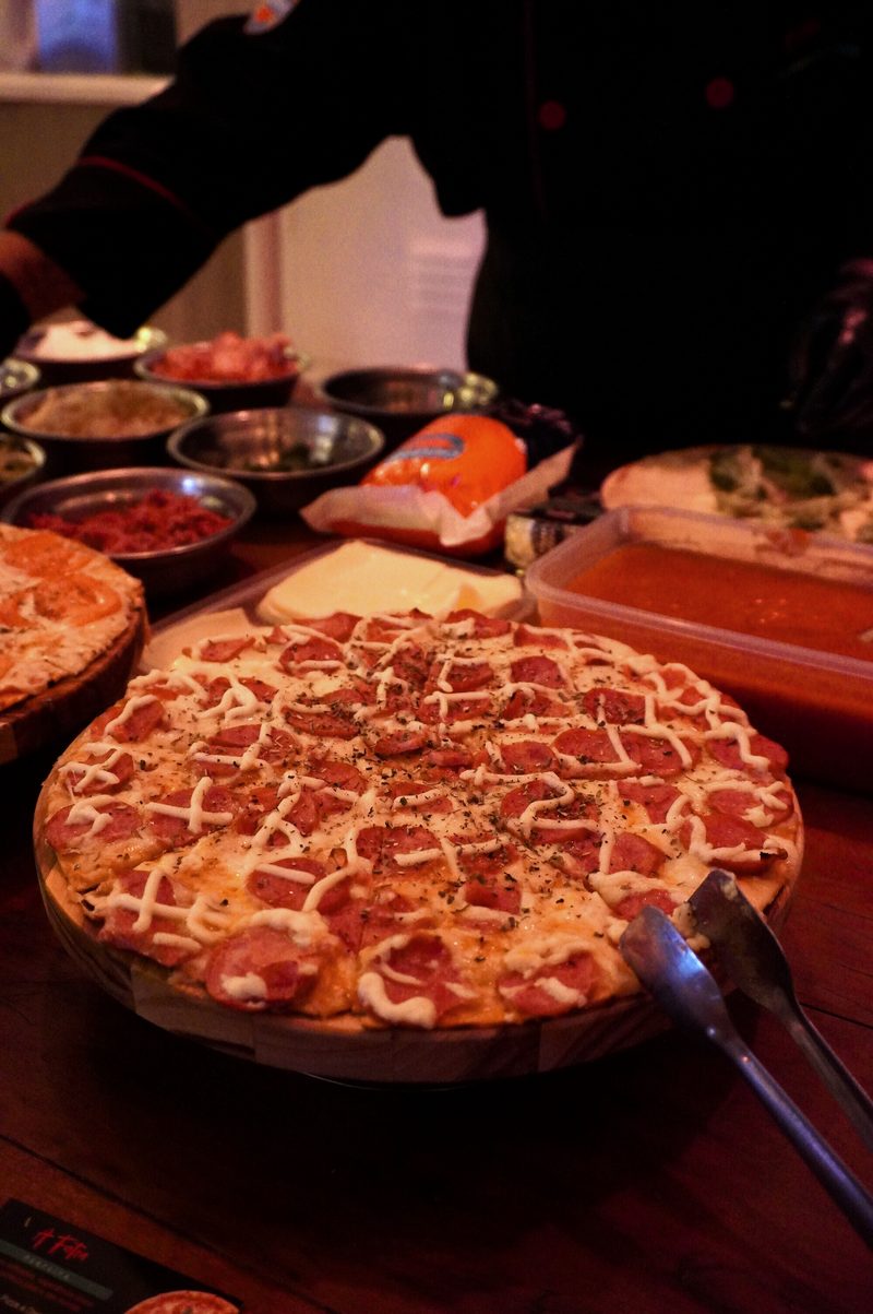 Mesa de serviço montada no evento com pizza pronta e insumos
